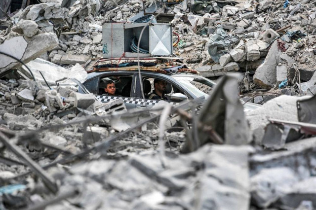 A vehicle moves past the rubble of collapsed buildings in Khan Younis in the southern Gaza Strip on September 16, 2024, amid the ongoing war in the Palestinian territory between Israel and Hamas